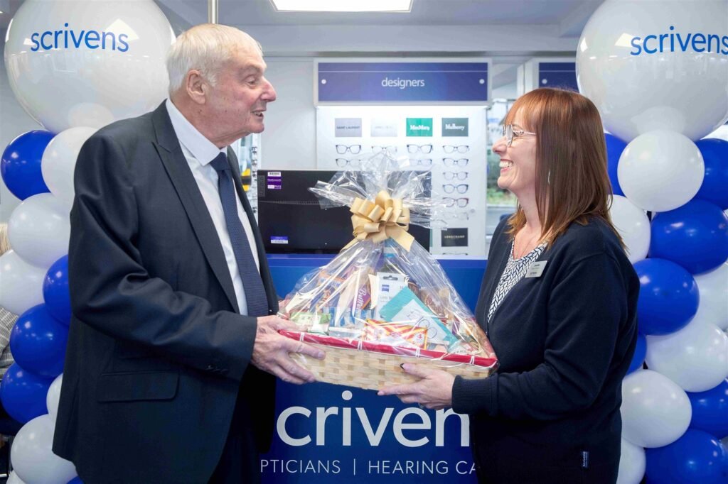 Ken Taylor receiving a hamper of goodies from branch manager Jeanette Green inside the Scrivens branch